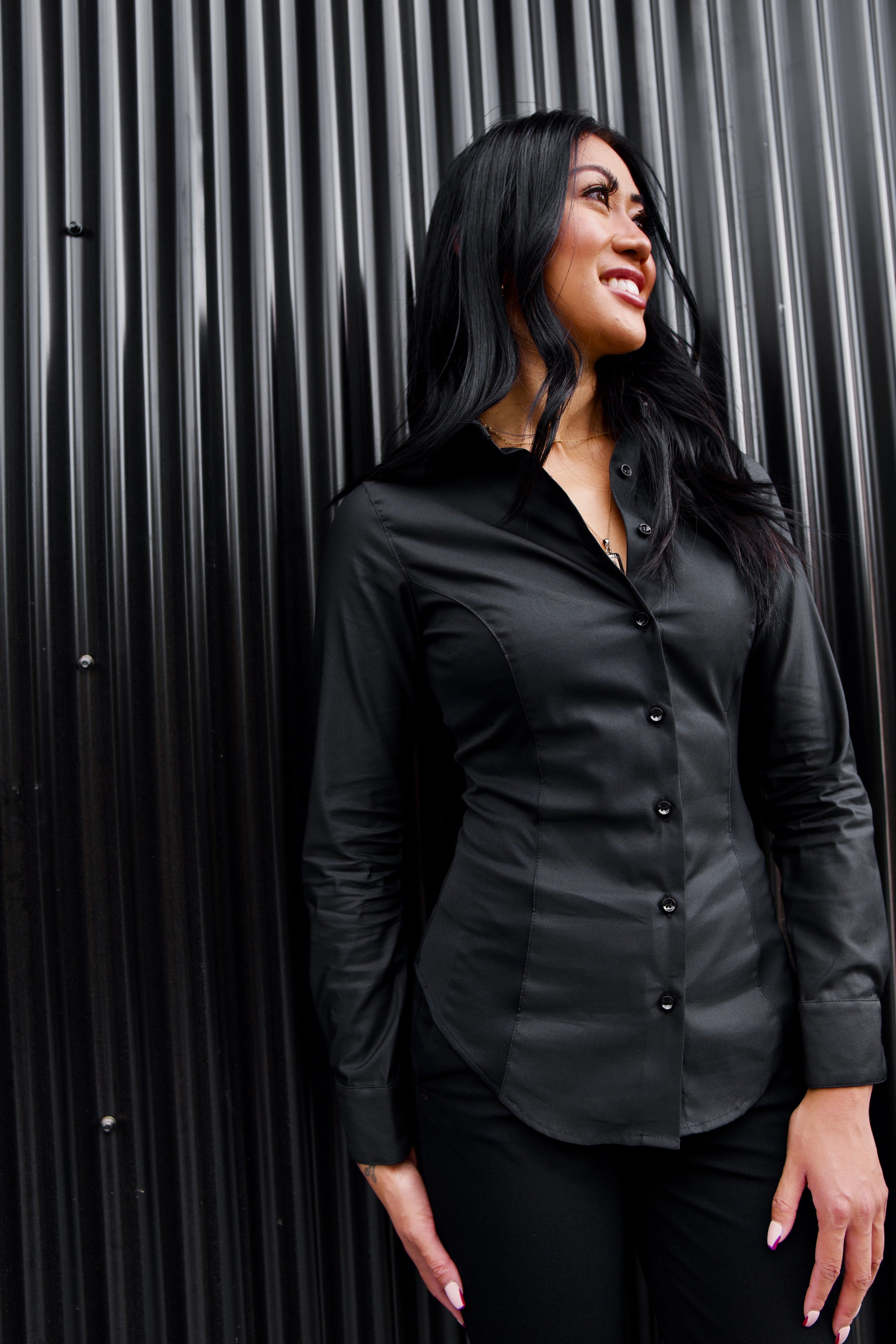 The front of a model wearing a black sweatproof dress shirt for women