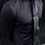 Man wearing a black Never-Iron Work Shirt with a black tie, showcasing its smooth, wrinkle-free fabric and fit.
