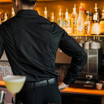 Men's Work Shirt slim fit sweat-proof design worn by bartender behind bar with drinks and bottles.
