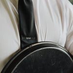 6AM Tie Clip black stainless steel engraved logo on black tie worn with white shirt and jacket