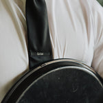 6AM Tie Clip black stainless steel engraved logo on black tie worn with white shirt and jacket