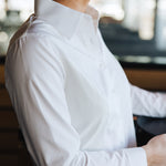 Profile view of a woman wearing a white Women's Work Shirt with a crisp collar and fitted design.