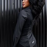 The back of a model wearing a black sweatproof dress shirt for women