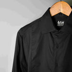 The front of a black sweatproof dress shirt for men on a wooden hanger