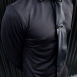 Man wearing a black Never-Iron Work Shirt with a black tie, showcasing its smooth, wrinkle-free fabric and fit.