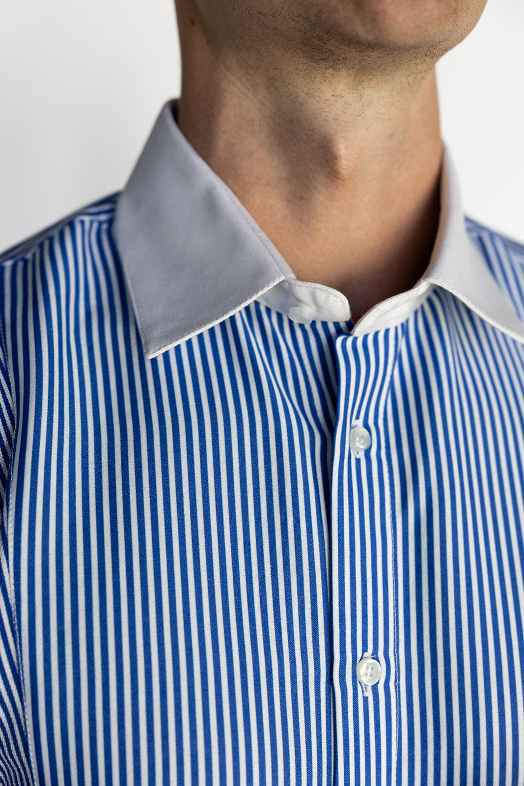 Close-up of a person wearing a blue and white striped shirt with a gray collar.
