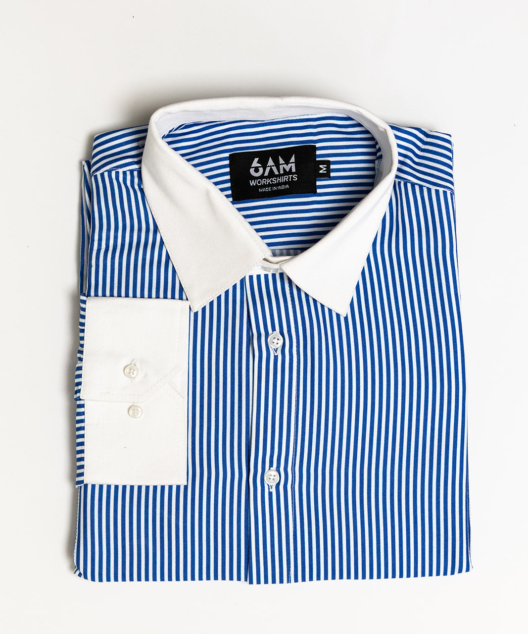 Folded blue and white striped shirt with a visible brand label on a light gray background