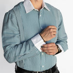 Man wearing a green and white striped dress shirt with black pants on a white background