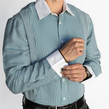 Man wearing a green and white striped dress shirt with black pants on a white background