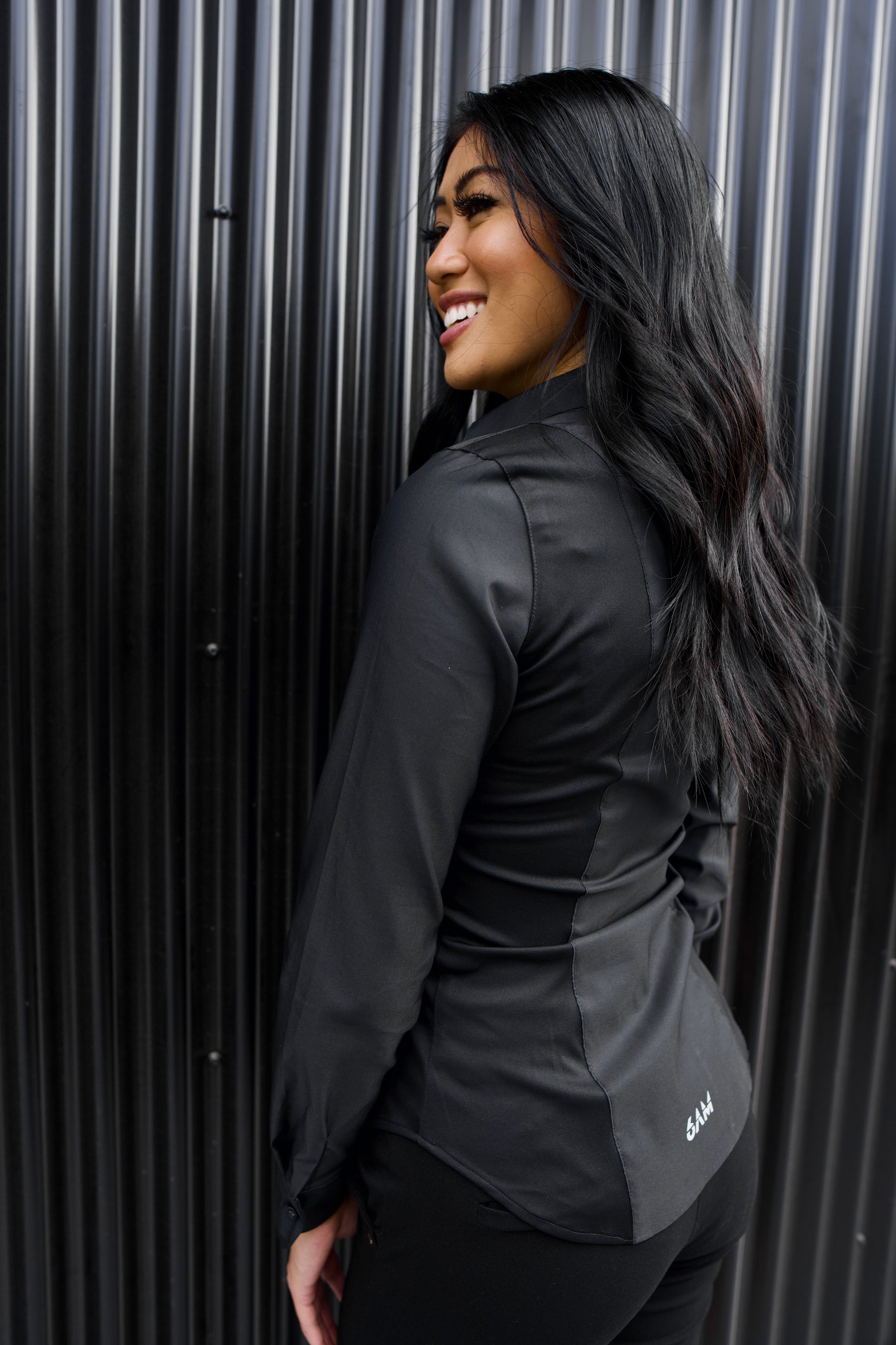 The side of a model wearing a black sweatproof dress shirt for women