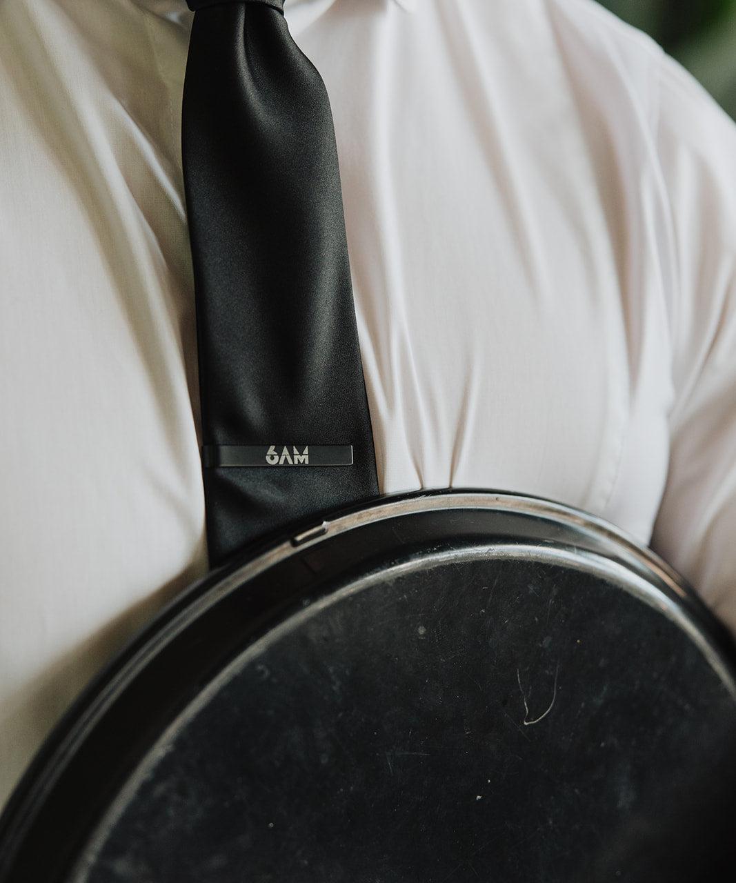 6AM Tie Clip black stainless steel engraved logo on black tie worn with white shirt and jacket