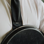 6AM Tie Clip black stainless steel engraved logo on black tie worn with white shirt and jacket