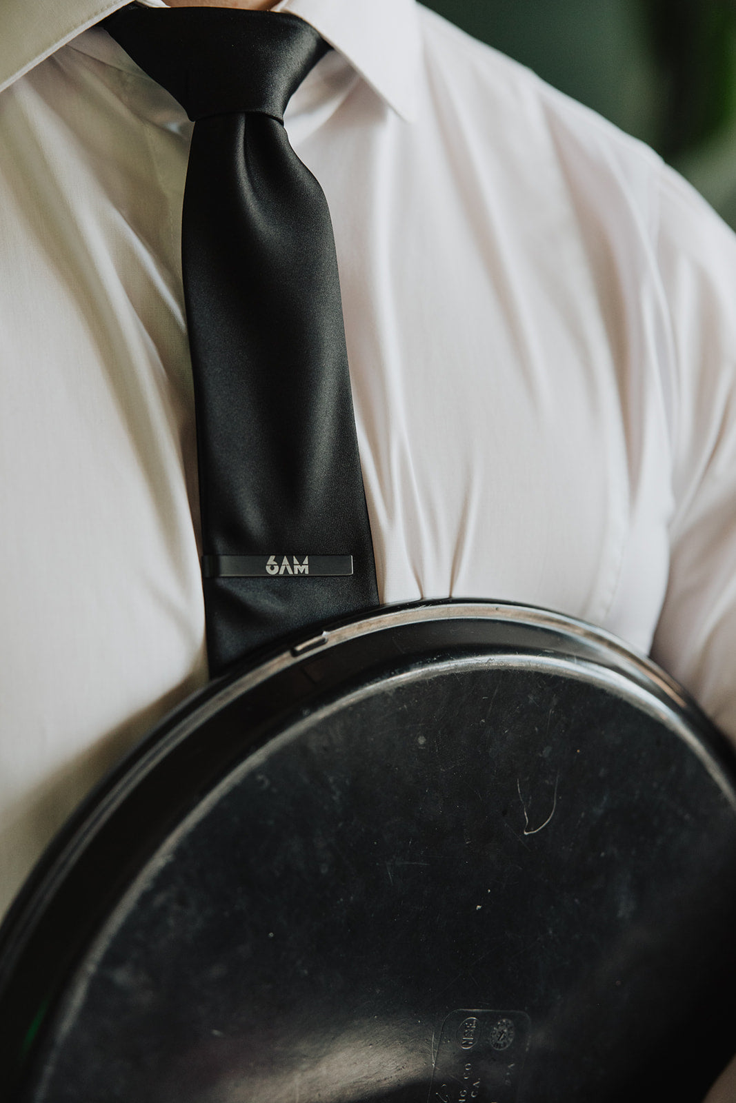 6AM Tie Clip black stainless steel engraved logo on black tie worn with white shirt and jacket