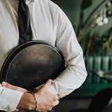 6AM Formal Black Tie worn with a white shirt featuring the 6AM logo on the tie tail, held by a person indoors.