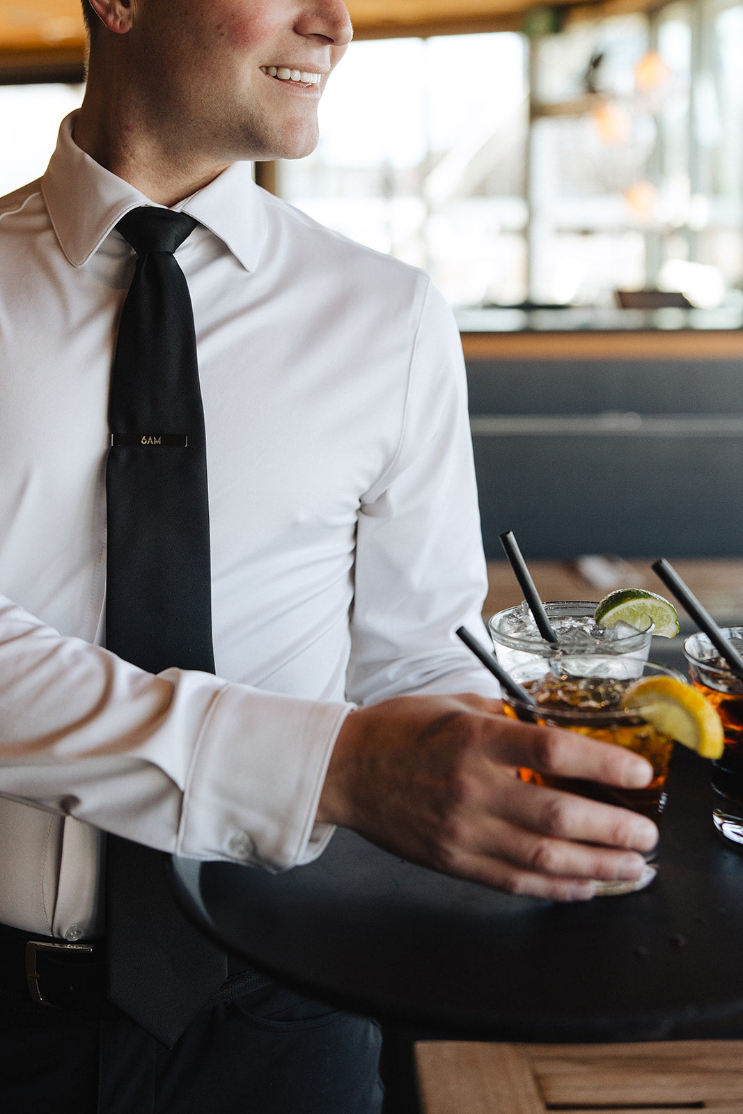 Man wearing a white Never-Iron Work Shirt serving drinks, showcasing its wrinkle-free and comfortable fit.
