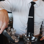 Man wearing a white Never-Iron Work Shirt with black tie serving drinks, showcasing wrinkle-free fabric and fit.