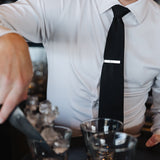 Man wearing a white Never-Iron Work Shirt with black tie serving drinks, showcasing wrinkle-free fabric and fit.