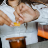 Woman wearing white Women's Work Shirt with form-fitting design preparing a drink in a bar setting.