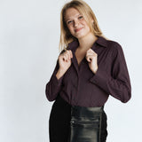 Woman wearing the Women’s Long Sleeve Bordeaux Arrowhead WorkShirt in a deep burgundy and black geometric pattern against a light background.