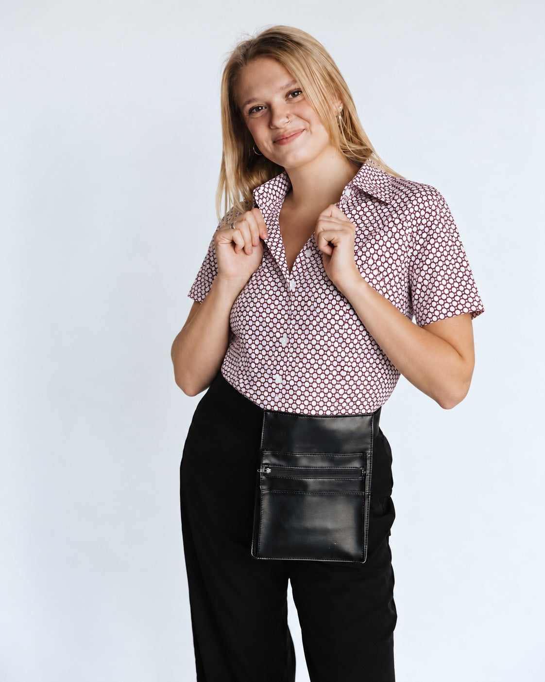 Woman wearing a red and white Hex Pattern short sleeve WorkShirt with black pants and a black server pouch