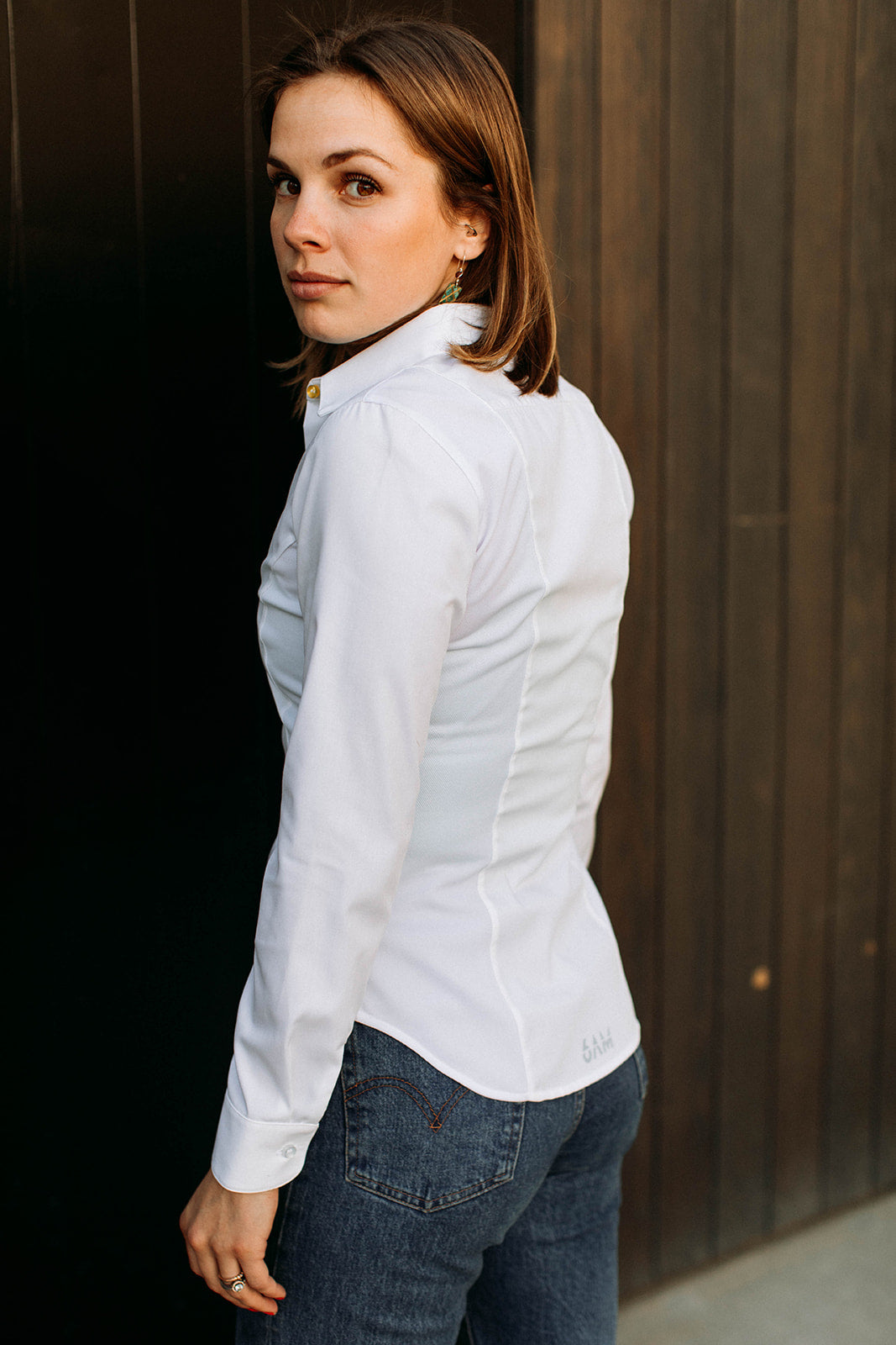 The back of a model wearing a white sweatproof dress shirt for women